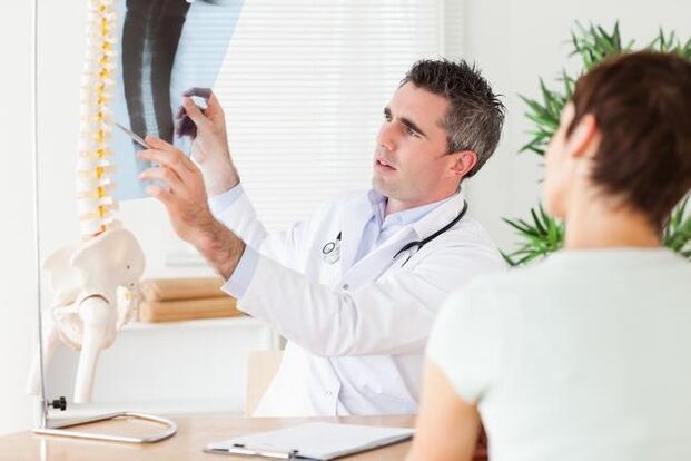 de arts toont de schade aan de wervelkolom als gevolg van cervicale osteochondrose